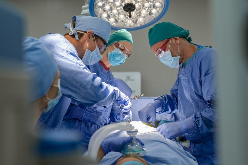 Medical team performing surgical operation in modern operating room. Surgery staff operating in a surgical room at hospital. Concentrated surgeons working on patient in an operation theater. (Foto: banco de imagens)