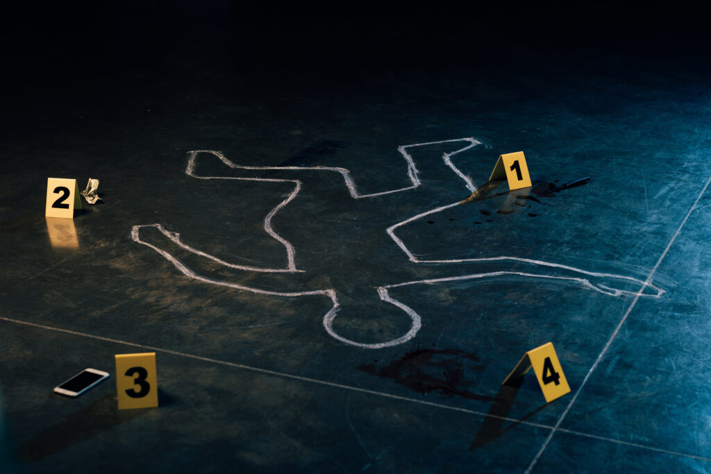 chalk outline and evidence markers at crime scene. (Foto: banco de imagens)